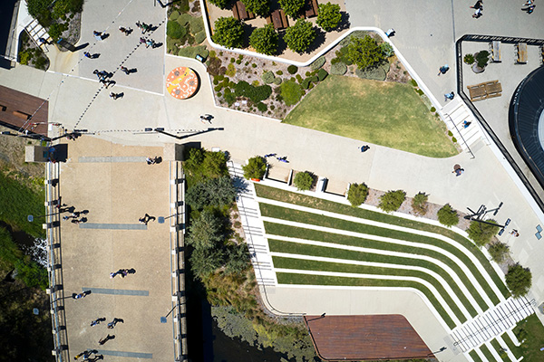 two women and a man walking through a university ggarden